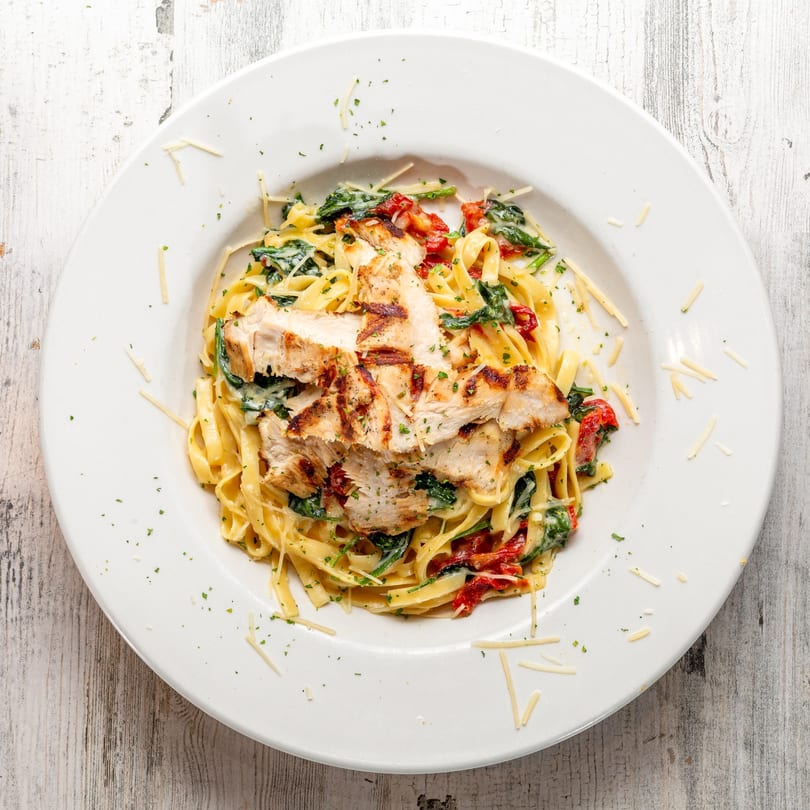 White Wolf Cafe's grilled chicken fettuccine alfredo with spinach, sun-dried tomatoes, and parmesan cheese.
