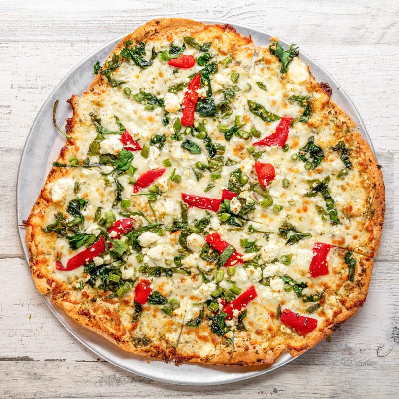 White Wolf Cafe's flatbread pizza topped with cheese, spinach, red peppers, and green onions.